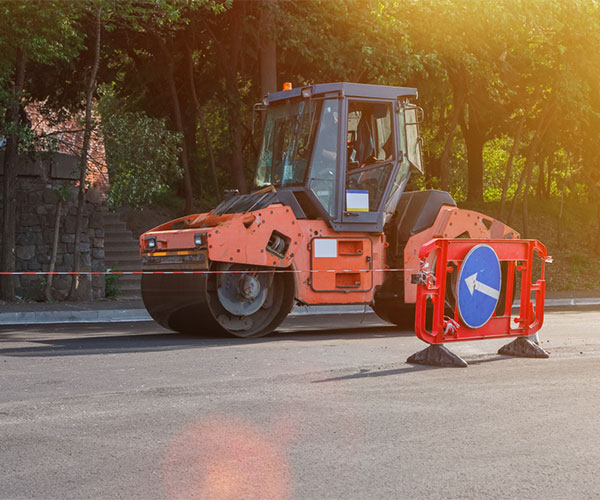 Steam roller driving over asphalt